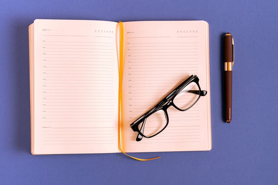 Osoba zapisująca cele w minimalistycznym notatniku przy biurku.